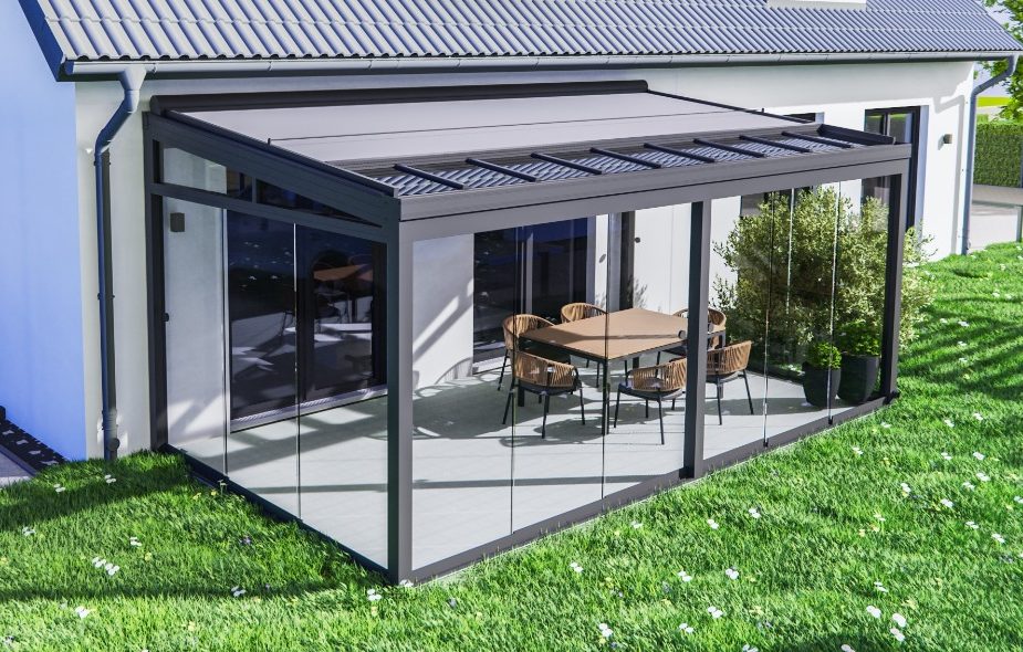 Moderne Terrassenüberdachungen mit Glaswänden, Tisch und Stühlen, umgeben von Rasen.